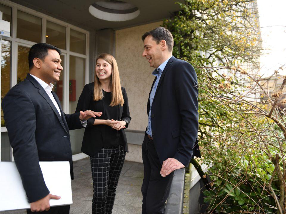 a woman and two men talking